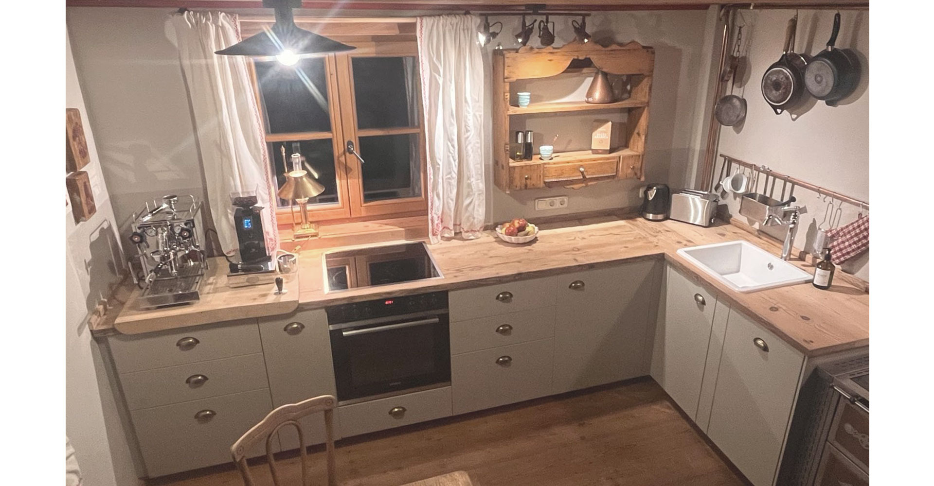 Urige Einbauküche in Almhütte mit Messing Muscheln, Echtholzplatte mit Patina in modernem-retro Stil