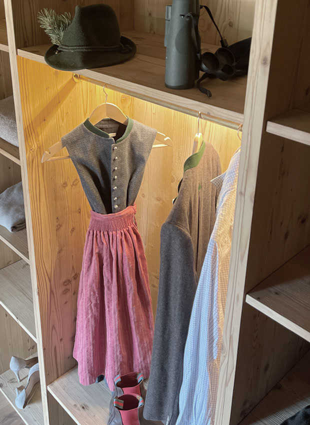 angestrahltes Dirndl im maßgefertigten Einbauschranks der Holzmanufaktur mit Messing Details und integrierter Lichtschiene